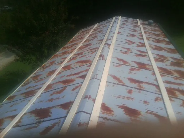 Rusted metal roof panels with new wood purlins before replacement — Storm Damage Roof Repair in Tiro by Roofing Brothers