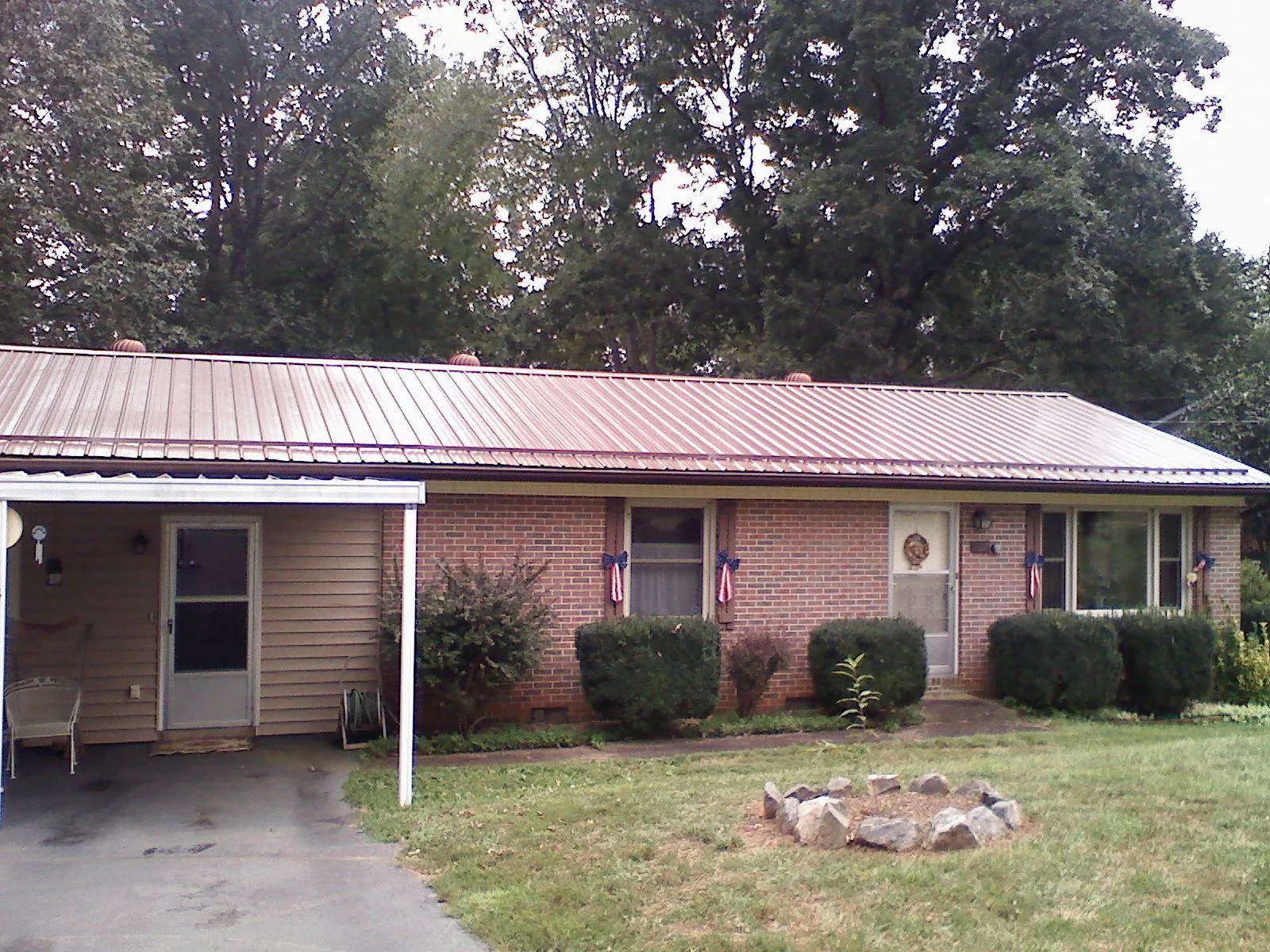 Bronze metal roof and carport on a brick ranch home — Roof Repair work by our crew in Tiro